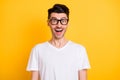 Photo of funky impressed young man wear white t-shirt spectacles open mouth isolated yellow color background