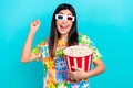 Photo of funky lucky woman dressed flower print t-shirt rising fist eat pop corn watching vr film isolated blue color Royalty Free Stock Photo