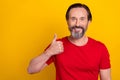 Photo of funky mature brunet man thumb up wear red t-shirt isolated on yellow color background Royalty Free Stock Photo