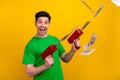 Photo of funky successful man with stylish haircut dressed green t-shirt hold guns shooting money isolated on yellow