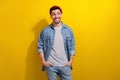 Photo of funky thoughtful man dressed jeans shirt looking empty space isolated yellow color background