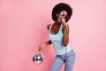 Photo of funky young dark skin woman wear jeans hold disco ball mic singer isolated on pink color background Royalty Free Stock Photo