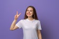 Photo of funny adorable young woman hand fingers show v-sign symbol, peace gesture, with a happy smile on face, standing over Royalty Free Stock Photo