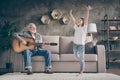 Photo of funny aged old grandpa little pretty granddaughter playing guitar dancing having fun bonding stay home