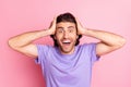 Photo of funny amazed guy hands head open mouth wear violet t-shirt isolated pastel pink color background Royalty Free Stock Photo