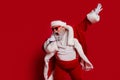 Photo of funny carefree entertainer retired man hold mic sing wear santa hat costume isolated red color background