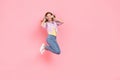 Photo of funny carefree inspired lady jump listen favorite song wear earphones jacket isolated pink color background