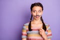 Photo of funny childish lady holding fake paper moustache mouth acting like guy masquerade party wear casual striped t