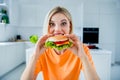 Photo of funny excited lady order deliver fast food cafe tasty big cheeseburger have bite in kitchen room Royalty Free Stock Photo