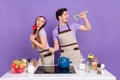 Photo of funny funky boyfriend girlfriend dressed chef singing kitchen microphones isolated purple color background