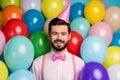 Photo of funny gentleman guy surrounded colorful balloons arranging birthday party wear paper cone cap pink shirt bow Royalty Free Stock Photo