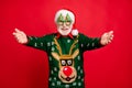Photo of funny grey haired santa glad children coming to newyear party want many hugs wear x-mas tree shape specs ugly
