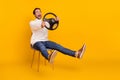 Photo of funny guy hold steering wheel sit chair car incident concept wear white pullover isolated yellow color Royalty Free Stock Photo