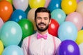 Photo of funny handsome gentleman guy surrounded colorful balloons arranging birthday party wear pink shirt bow tie Royalty Free Stock Photo