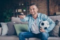 Photo of funny handsome guy stay home quarantine time watch football match champion league europe hold leather ball Royalty Free Stock Photo