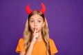 Photo of funny little lady headband horns play helloween party satan character holding finger on lips wear orange t- Royalty Free Stock Photo
