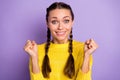 Photo of funny lucky young woman braids yellow pullover rising fists isolated purple color background