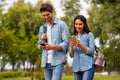 Photo of funny pair using telephones while walking green park wear casual denim outfit