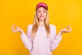 Photo of funny peaceful young lady wear pink sweater headwear smiling practicing yoga isolated yellow color background