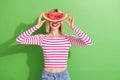 Photo of funny pleasant playful woman with bob hairstyle wear striped shirt hold watermelon on face isolated on green