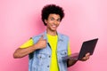 Photo of funny positive person demonstrate thumb up use netbook isolated on pink color background