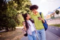 Photo of funny pretty friends couple dressed casual clothes backpacks drinking tea walking embracing smiling outdoors Royalty Free Stock Photo