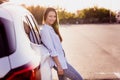 Photo of funny pretty young woman wear white shirt rising arms resting car smiling outside city street Royalty Free Stock Photo