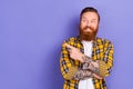 Photo of funny redhead bearded tattoo guy direct finger empty space tattoo salon banner isolated purple color background