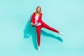 Photo of funny sweet orange hair woman dressed red jacket smiling dancing isolated cyan color background Royalty Free Stock Photo