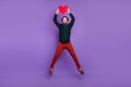 Photo of funny sweet young man wear smart casual outfit smiling rising big red heart jumping high isolated purple color