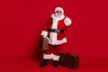 Photo of funny tourist old man prepare journey approve thumb up wear santa hat costume isolated red color background