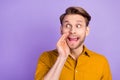 Photo of funny tricky young gentleman dressed yellow shirt arm mouth looking empty space isolated violet color