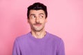 Photo of funny tricky young guy wear violet sweater looking empty space isolated pastel pink color background