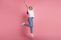 Photo of funny winner lady jump rejoice raise hands wear white t-shirt isolated on pink background