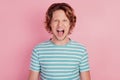 Photo of furious outraged crazy mad troubled man open mouth scream wear casual blue striped t-shirt on pink background