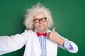 Photo of genius mature inventor dressed white uniform bow tie glasses tacking selfie showing thumb up isolated green
