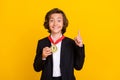 Photo of genius winner boy showing first place medal raise finger wear black uniform isolated yellow color background Royalty Free Stock Photo