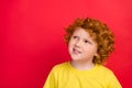 Photo of ginger dreamy inspired boy look up empty space wear yellow t-shirt isolated red color background