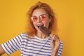 photo of girl eat icelolly ice cream at summer. girl with icelolly ice cream isolated on yellow.