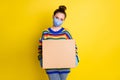 Photo of girl giving huge box wear blue mask gloves from corona rainbow sweater pants isolated on bright yellow color Royalty Free Stock Photo