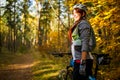 Photo of girl in helmet on bicycle in autumn forest