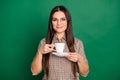 Photo of girl hold cup drink look camera wear glasses checkered shirt isolated green color background Royalty Free Stock Photo