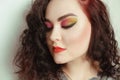 Photo of a girl portrait of a brunette with color makeup, shades of red, green, yellow. Gorgeous professional bright makeup. Girl