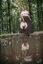 photo of a girl in the reflection of a puddle, in the forest