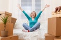 Photo of girl sitting on sofa among cardboard boxes