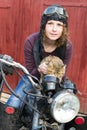 Photo of girl on a vintage motorbike in pilot cap with cat Royalty Free Stock Photo