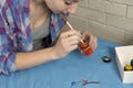 Photo of girl who drawing acrylic paints on blue clothes