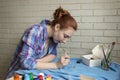 Photo of girl who drawing acrylic paints on blue clothes