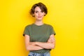 Photo of girlish pretty confident nice girl with bob hairstyle wear khaki t-shirt arms crossed isolated on yellow color