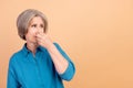 Photo of gloomy woman with bob hairstyle dressed stylish shirt looking at empty space close nose isolated on beige color Royalty Free Stock Photo